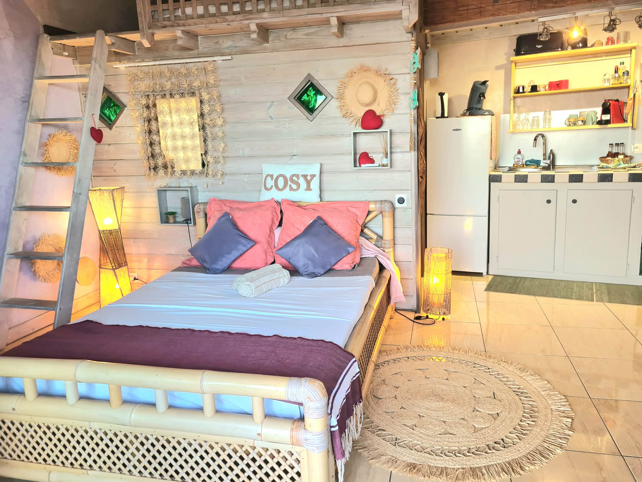 Intérieur du bungalow : lit, kitchenette et mezzanine