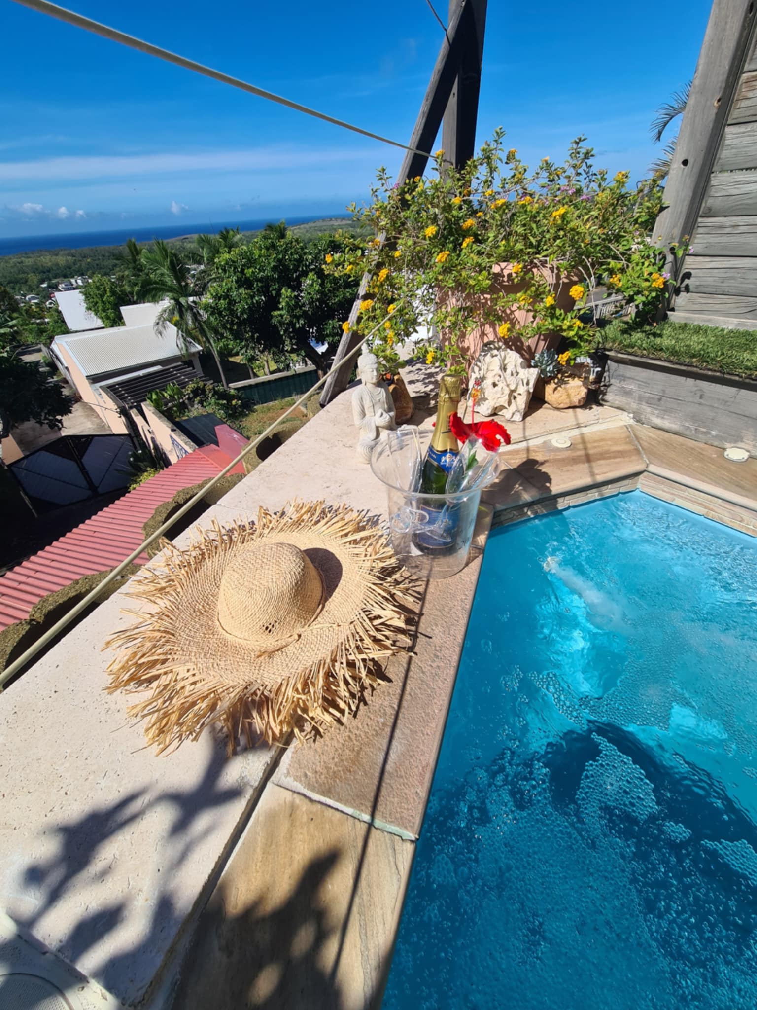 Spa privatif avec chapeau de paille et champagne, vue océan